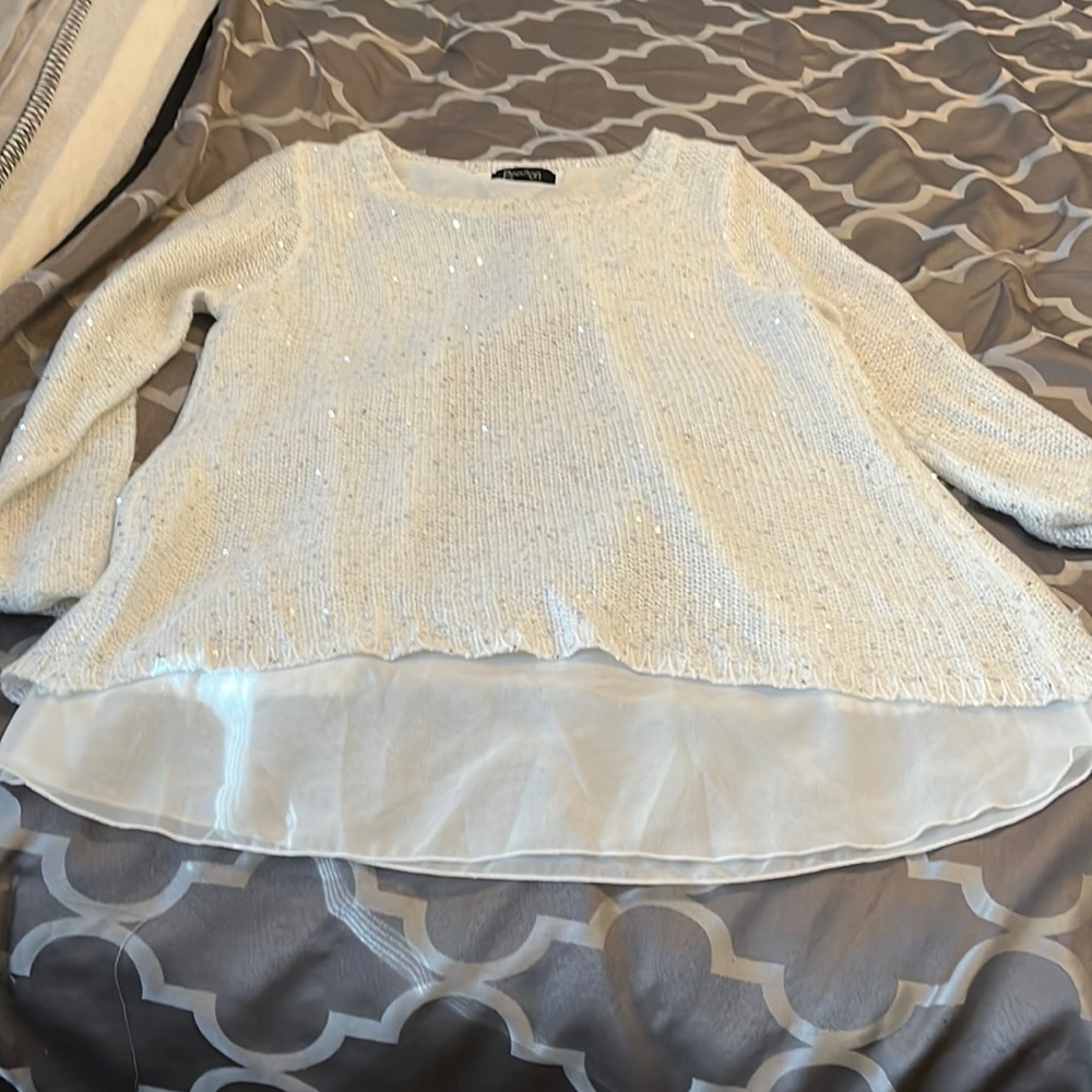 White sparkly sweater with small tear over the left bosom